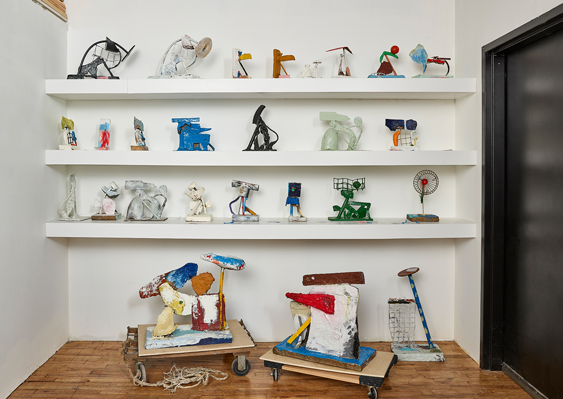 View of Eddie Martinez studio with rows of sculptures on shelves