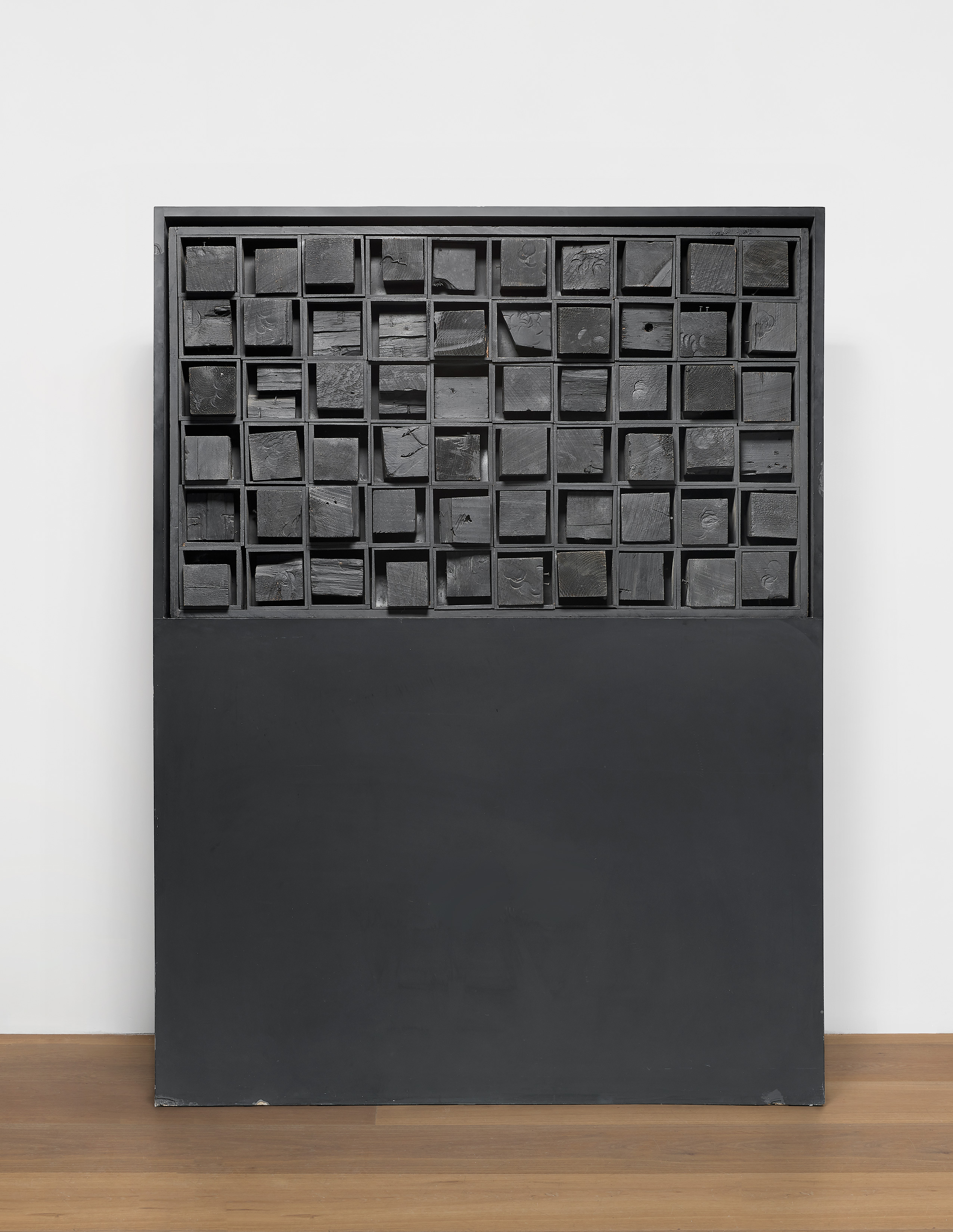 Installation view of Louise Nevelson's black painted wood sculpture Ancient Secrets II