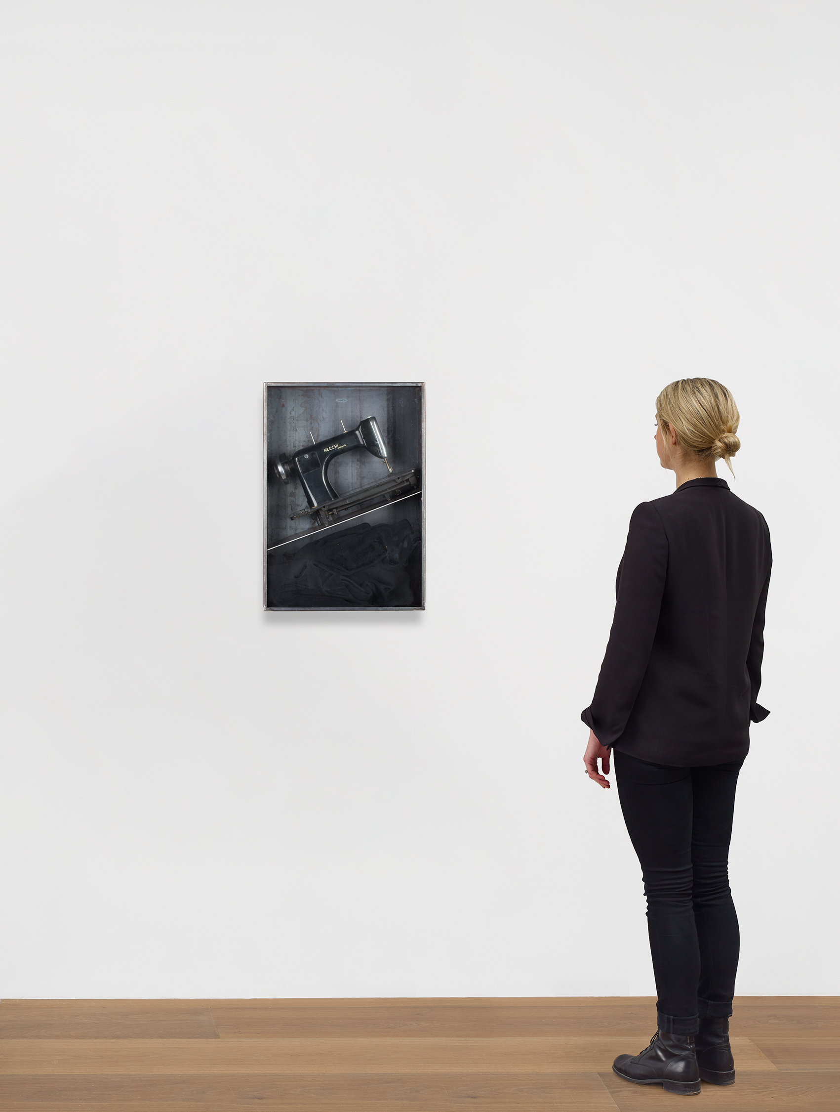 Scale view of Jannis Kounellis's Metal and glass box with sewing machine and black coat work Untitled (Sewing Machine)