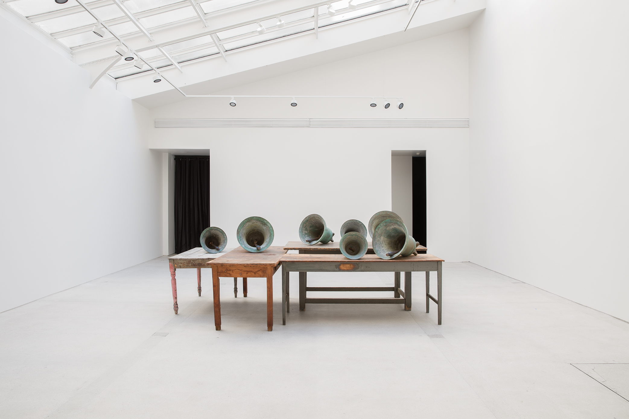 Installation view of Jannis Kounellis's Untitled wooden tables and bronze bells work